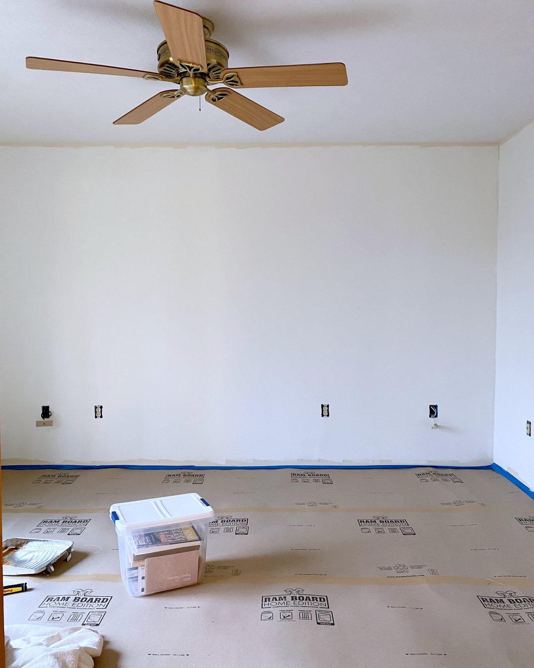 bedroom with ram board on floor and simply white paint on walls