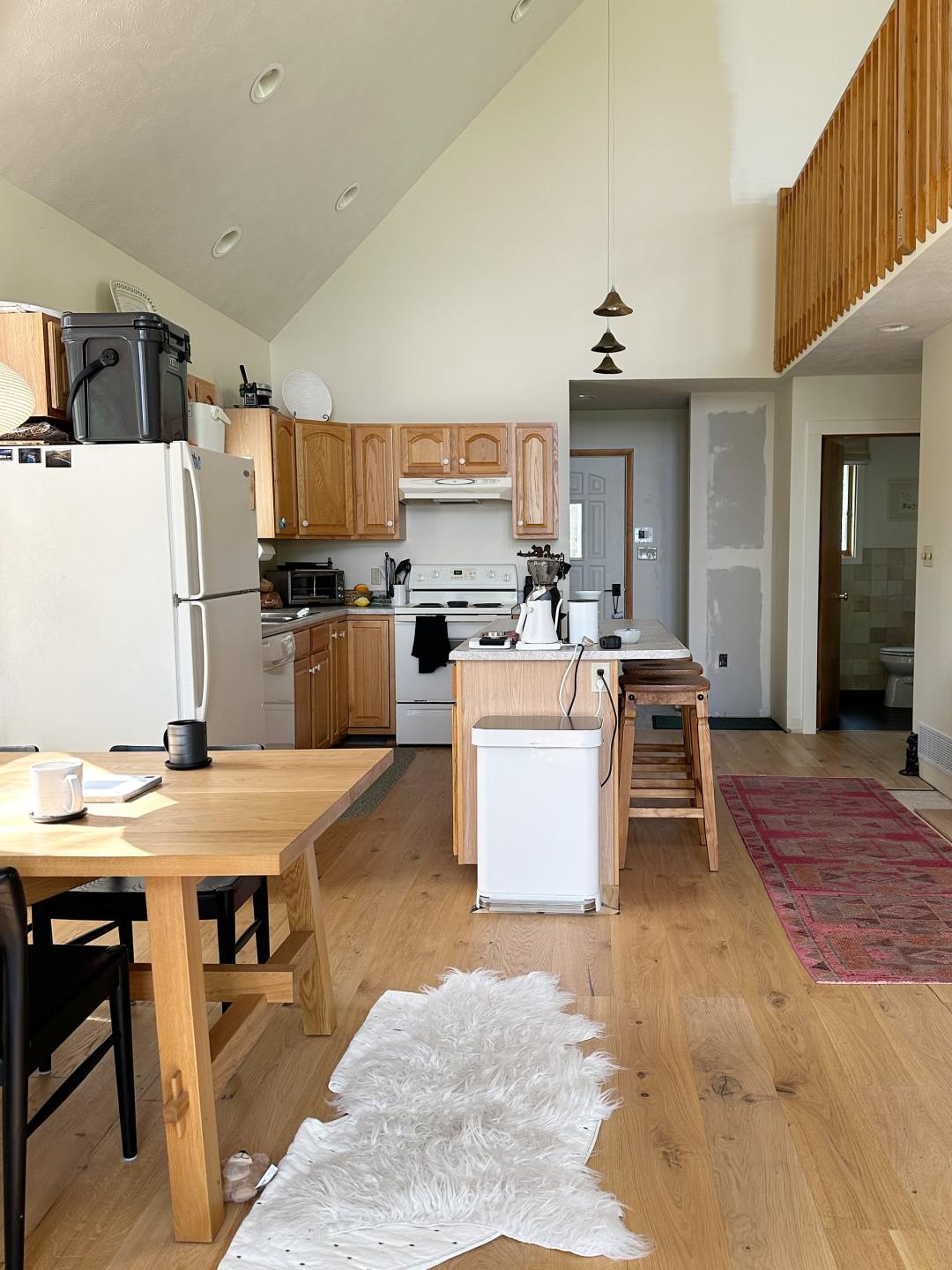 A dated oak cabinet kitchen with high sloped ceiling.