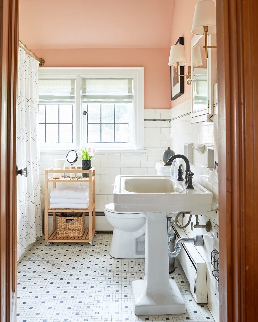 Blush bathroom with linen roman shades and classic tile